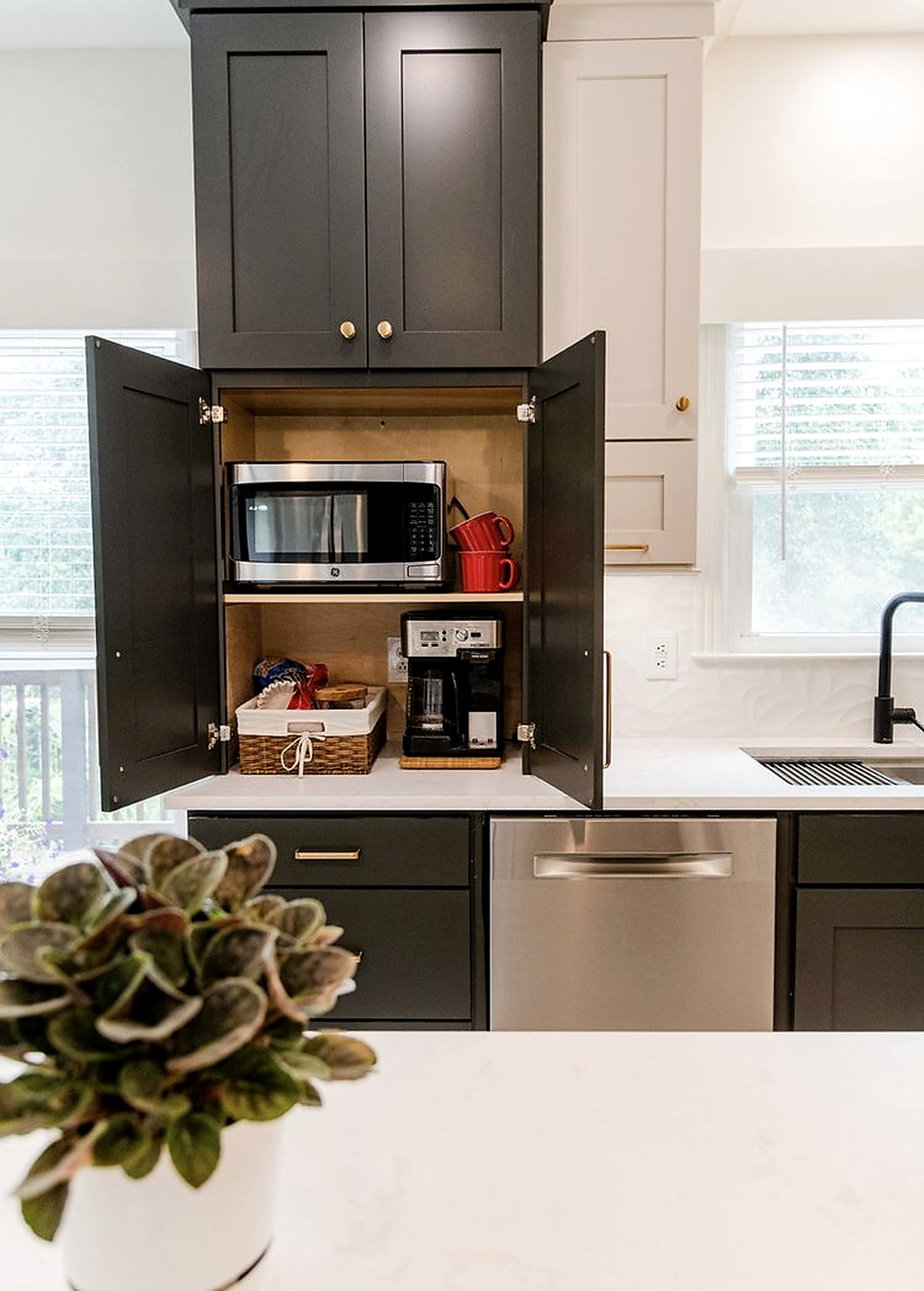 Appliance garage cabinet concealing a microwave and coffee station