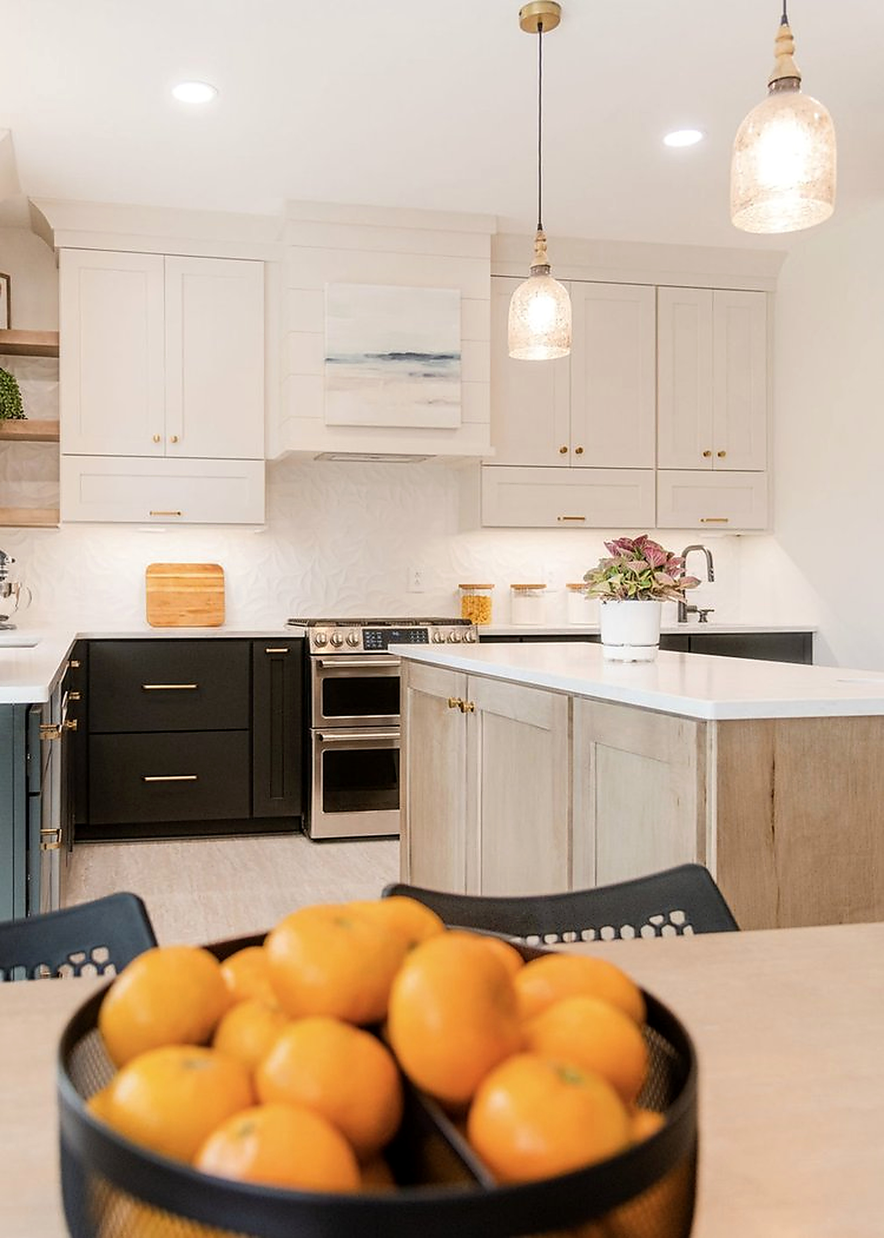 Charcoal cabinetry with quartz countertops and brass hardware